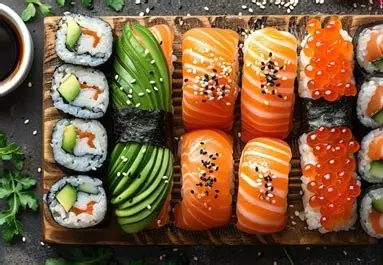 Assorted fresh sushi rolls, nigiri and sashimi on a wooden board